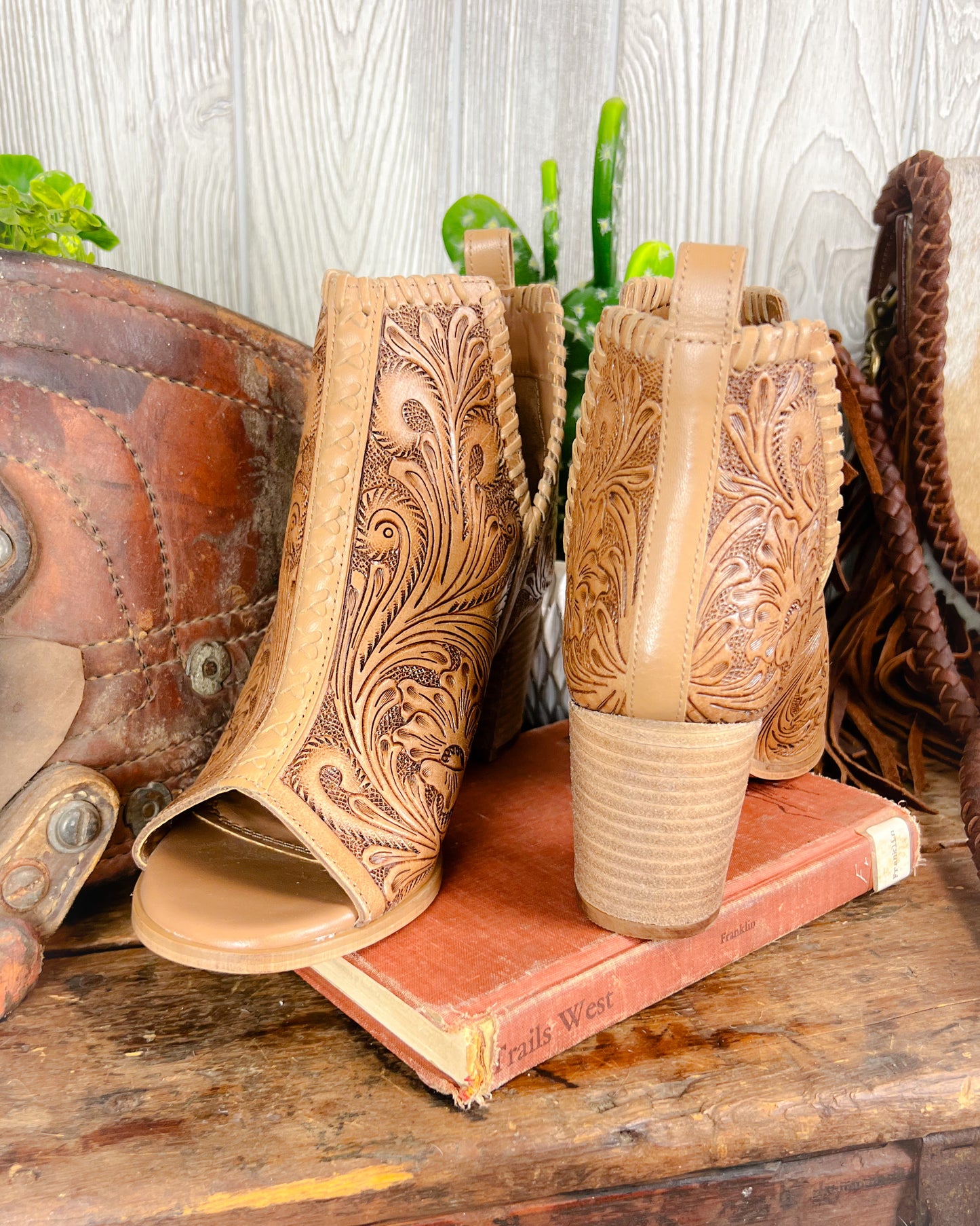 Back view of high heeled western booties with 2-inch stacked heel and floral tooling