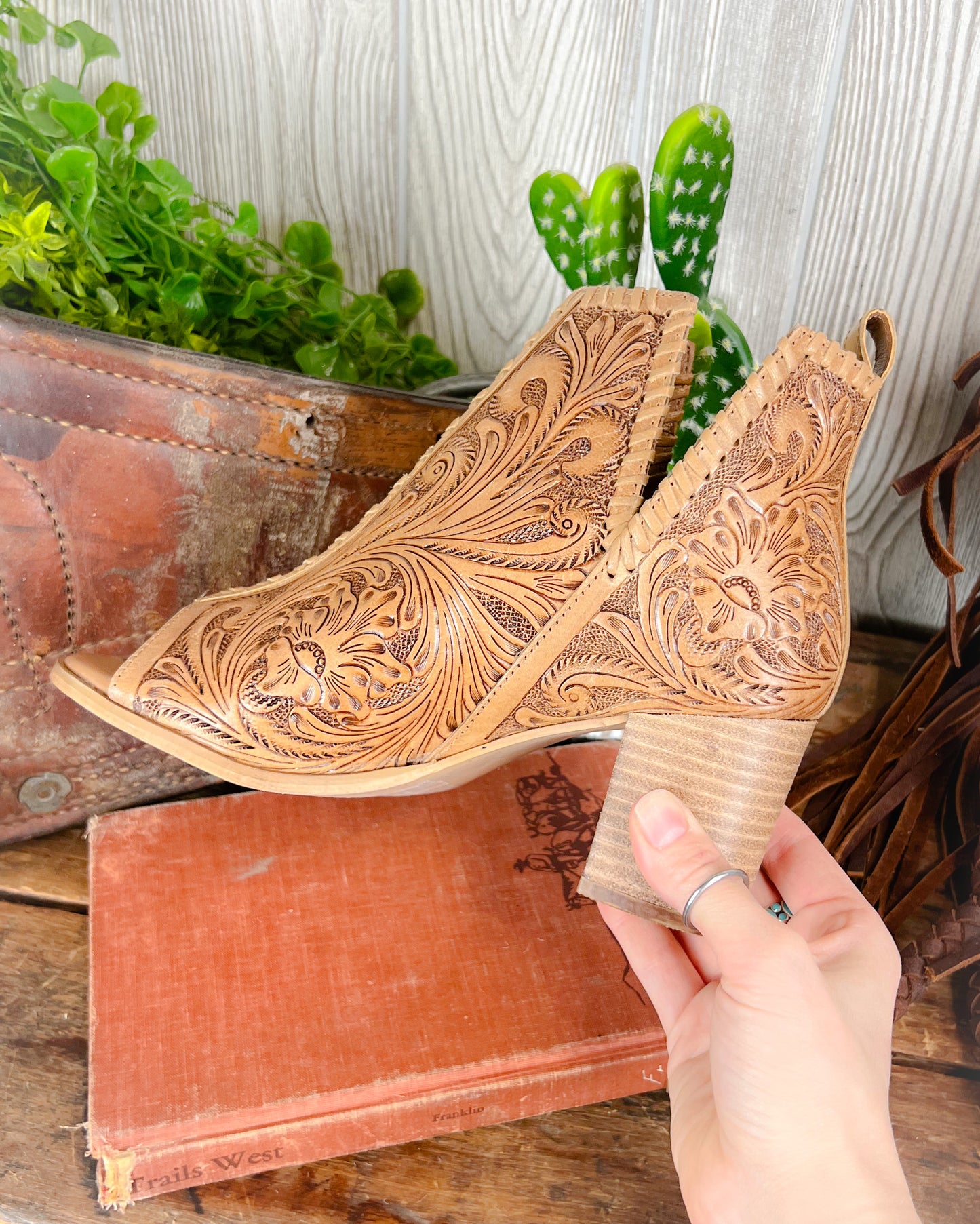 ide view of cowgirl booties with tooled leather, open toe, 2-inch heel, and side slit