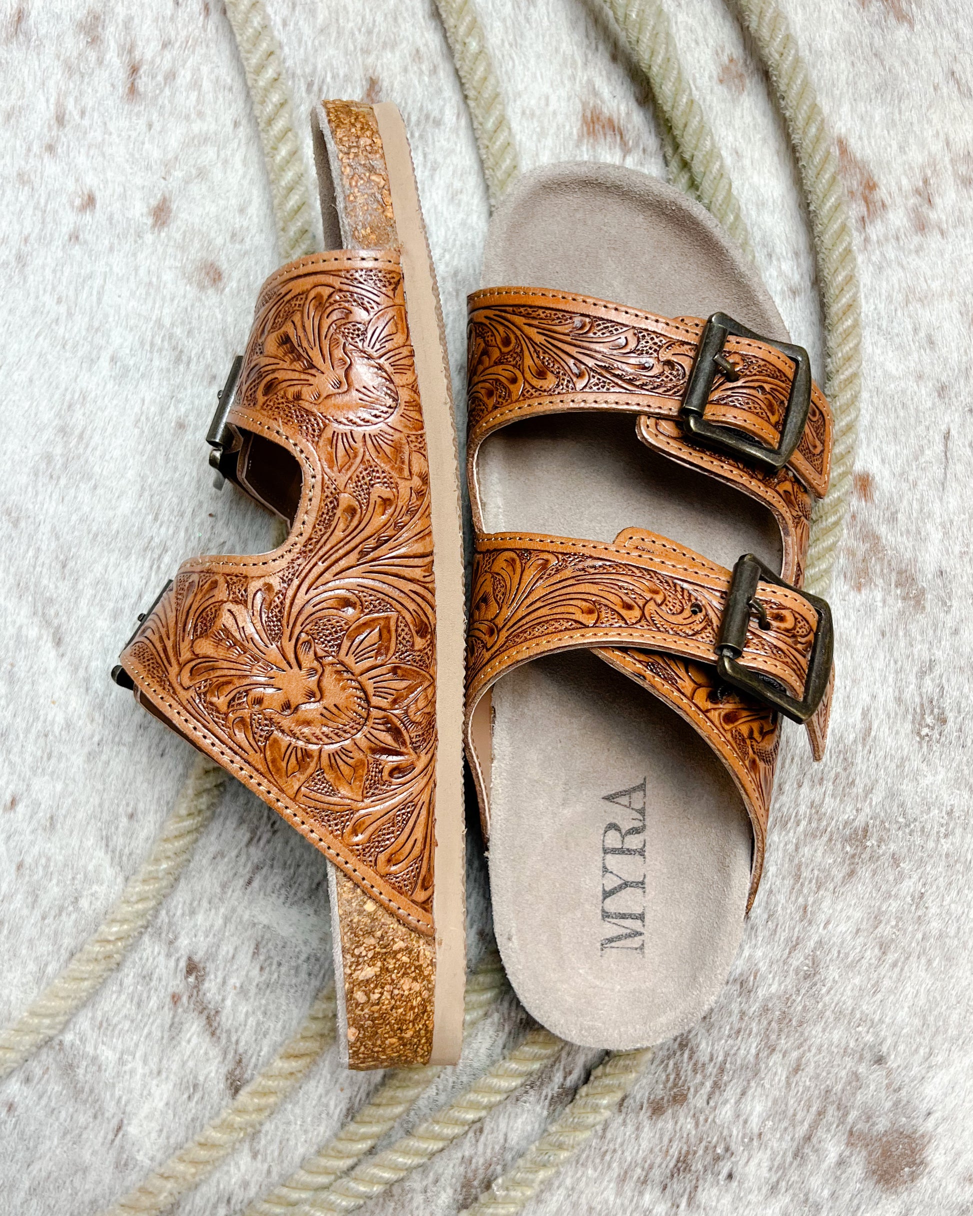 Side view of western-inspired tooled leather sandal with floral pattern and soft footbed