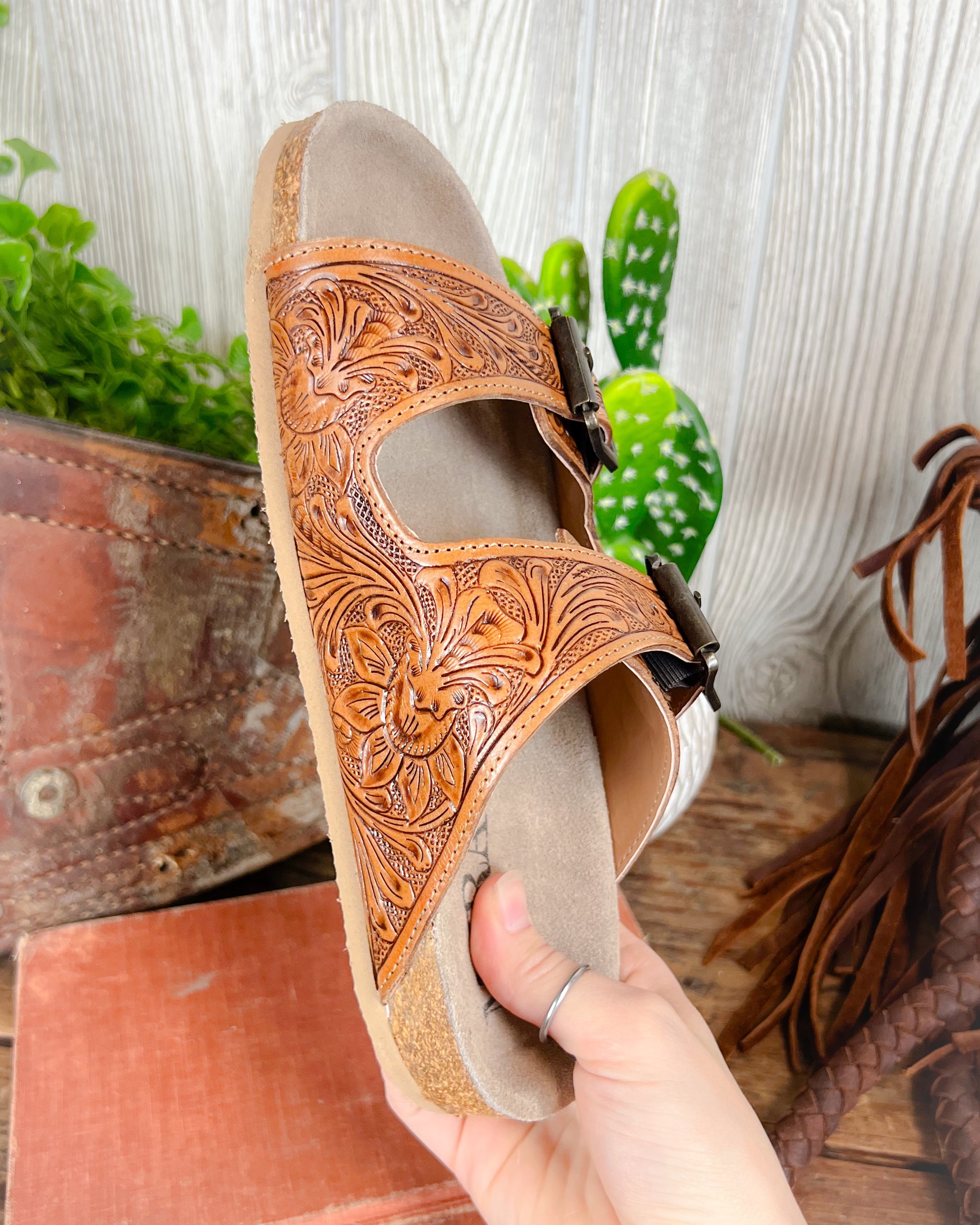 Floral tooled leather Birkenstock-style sandals with adjustable straps and cushioned sole