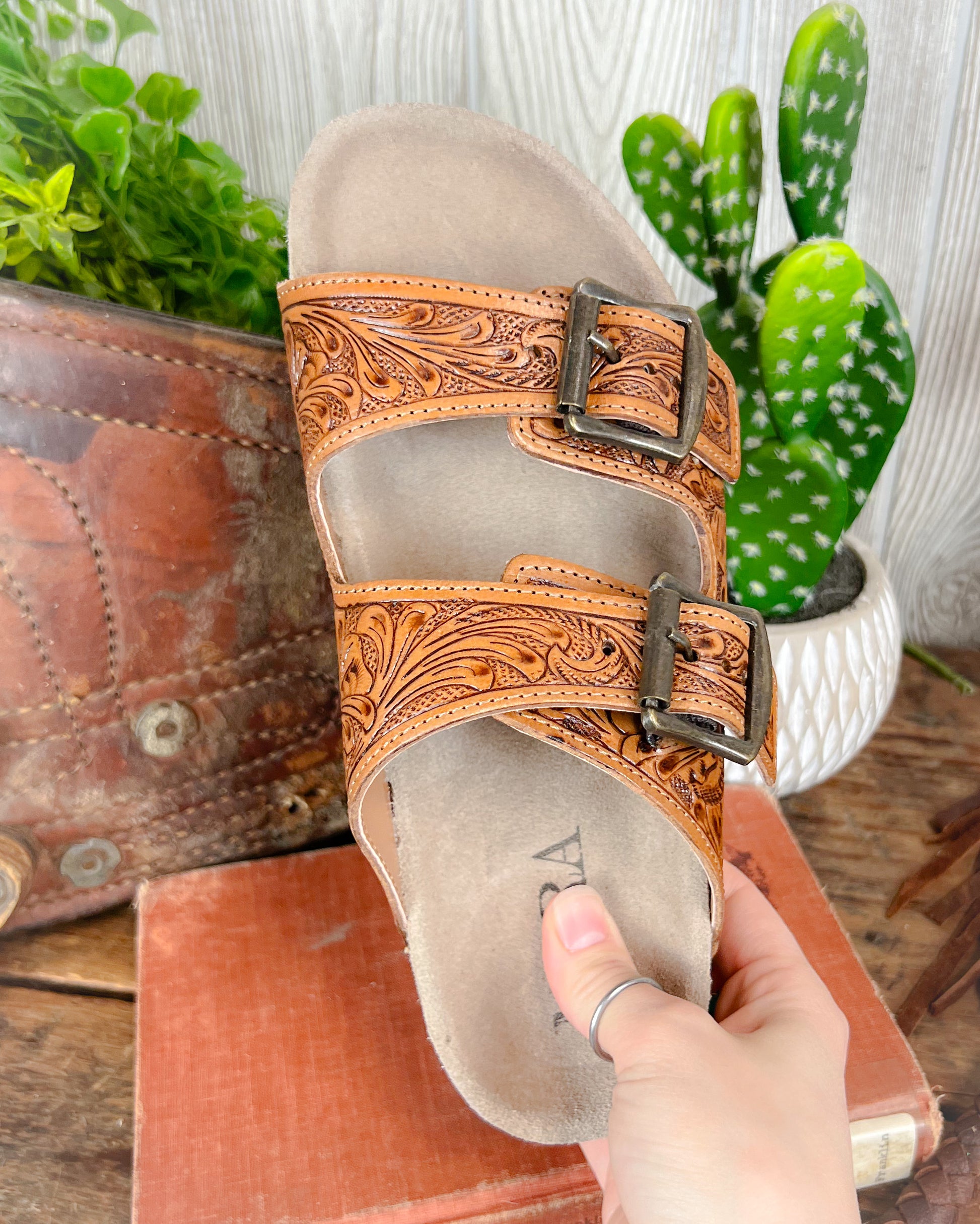 Top-down view of floral tooled leather sandals with double adjustable straps and contoured sole