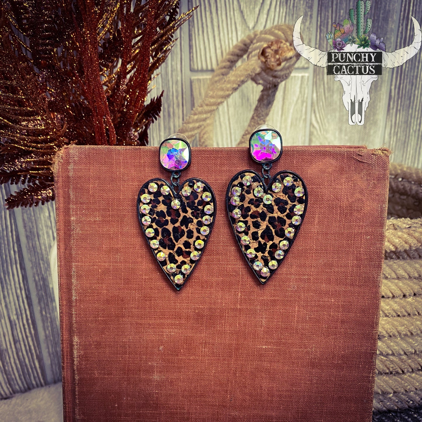 black metal heart shaped earrings with cheetah print center and rhinestones around the edge