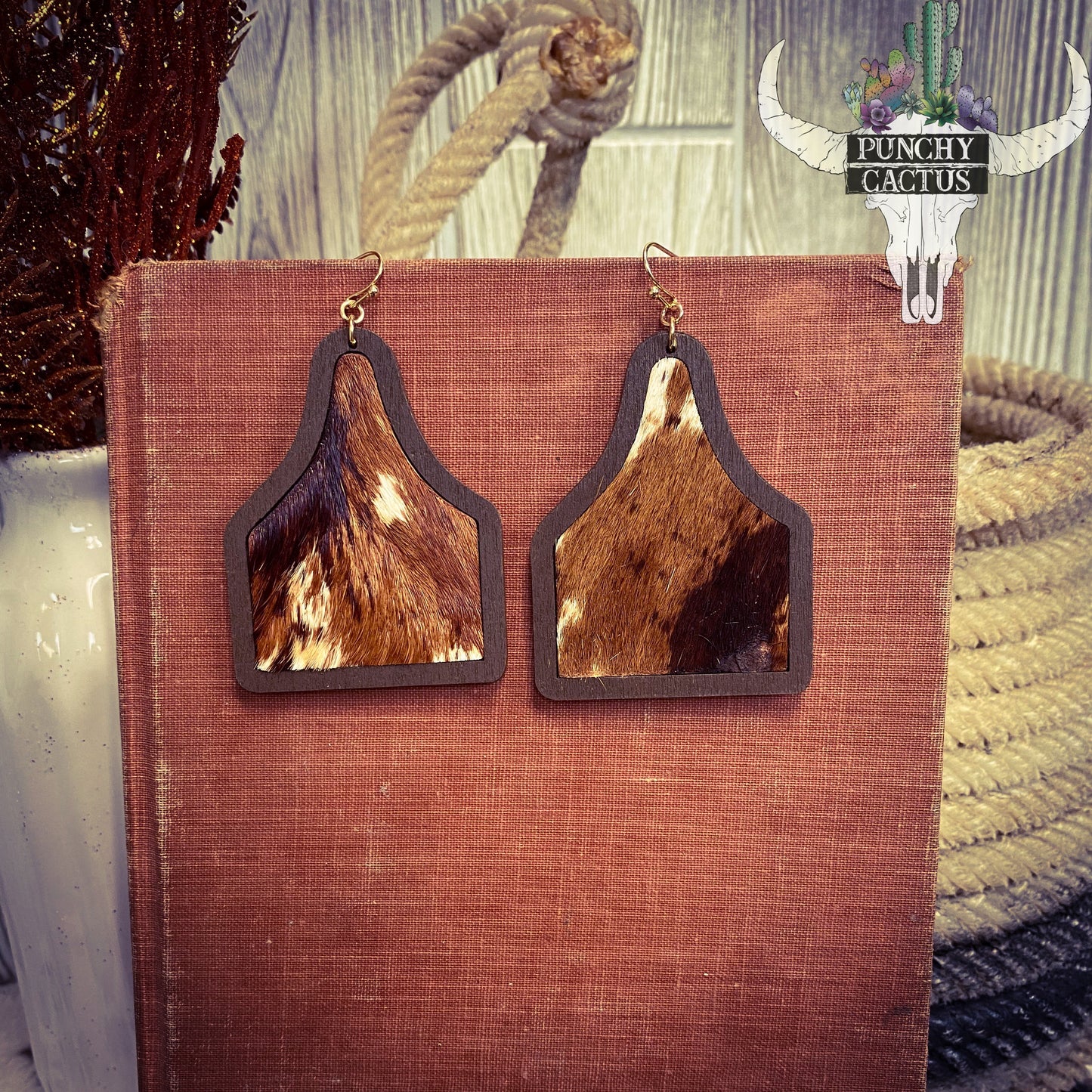 cow eartag shaped earrings with brown and white cow hide center