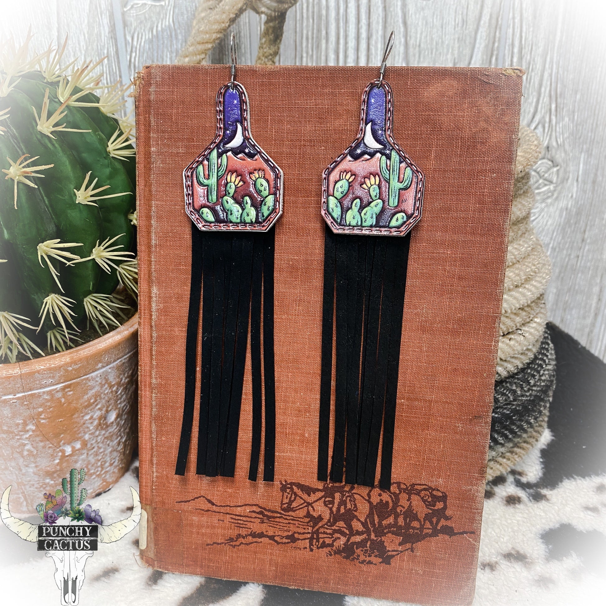 western leather cow tag earrings with cactus tooled design and black leather fringe
