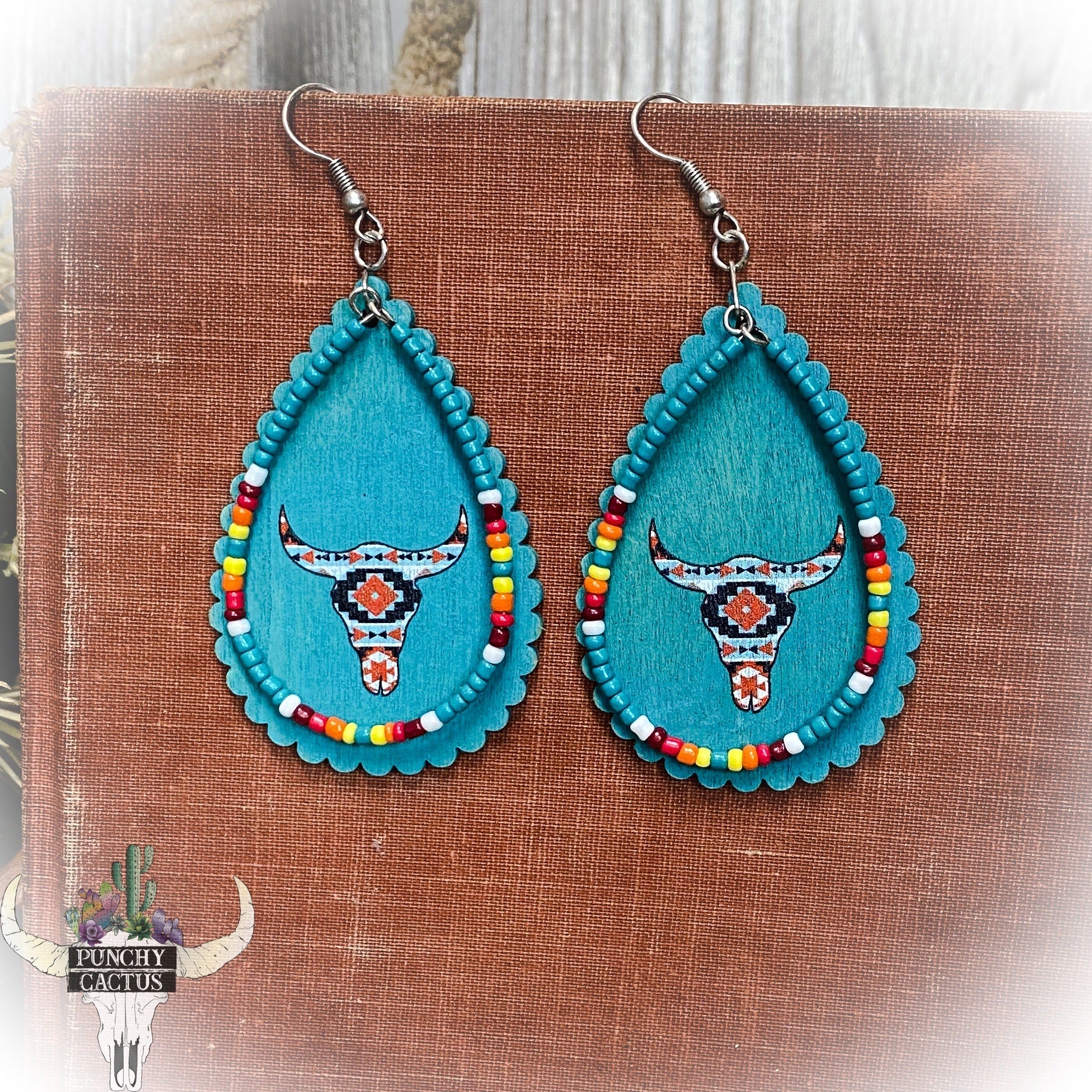 wooden western turquoise earrings with aztec print bull skull and turquoise serape seed bead dangle